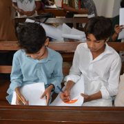 Crianças desenham durante uma aula de educação religiosa dentro de uma igreja.