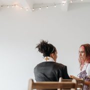Pastora conversa com outra mulher em um ambiente tranquilo de uma igreja.