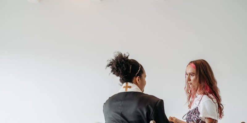 Pastora conversa com outra mulher em um ambiente tranquilo de uma igreja.
