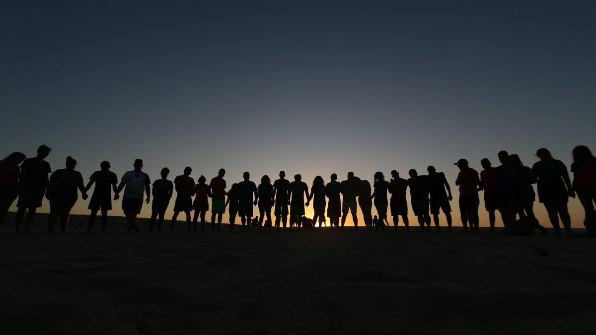 Grupo de jovens reunidos ao ar livre em um momento de convivência e oração, associado a uma comunidade religiosa.