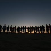 Grupo de jovens reunidos ao ar livre em um momento de convivência e oração, associado a uma comunidade religiosa.