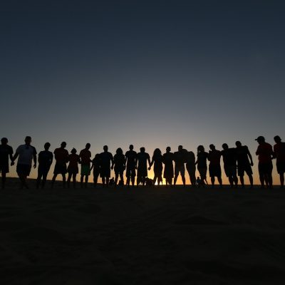 Grupo de jovens reunidos ao ar livre em um momento de convivência e oração, associado a uma comunidade religiosa.