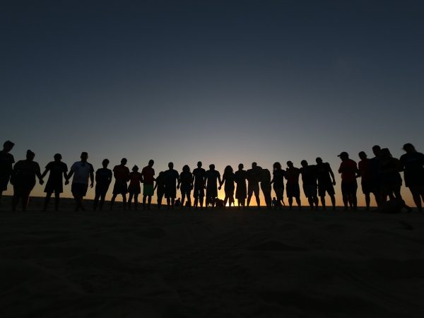 Grupo de jovens reunidos ao ar livre em um momento de convivência e oração, associado a uma comunidade religiosa.
